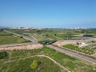 Aerial drone view of a road bridge over a railway surrounded by farmland