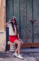 Young woman in stylish summer outfit sitting