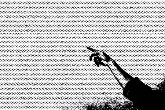Black and white image of a hand pointing upwards against a textured background
