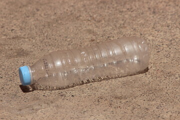 An empty plastic bottle lying on the ground