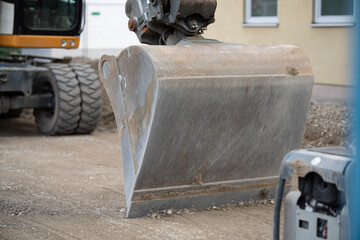 Heavy Excavator Bucket Attached To Yellow Construction Machinery: Dirt Ground And Greenery...