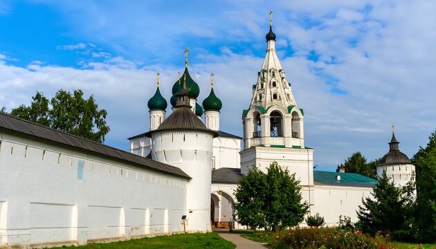 White stone church complex with green domes and tall towers.