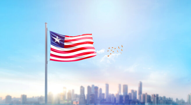 Liberia  national flag waving with skyline and buildings. Liberia national flag for independence day.