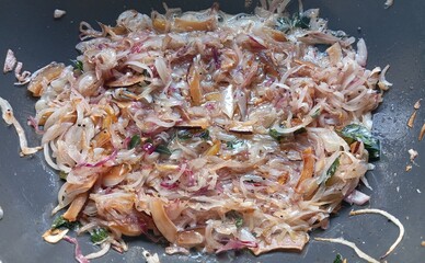 Chicken sukha masala base preparation with sliced onions, dry coconut slices, mustard seeds, curry leaf's and garlic paste sautéed in oil to create the traditional Indian semi-dry spicy chicken curry.