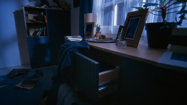 Floor of living room covered with scattered clothing, personal belongings and opened drawers after housebreaking
