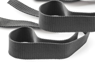 two strands of gray coarse textured nylon fabric belt isolated on white background