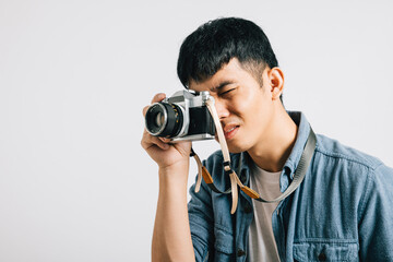 Portrait of a happy young man ready for his close-up with a vintage camera. Studio shot isolated on...