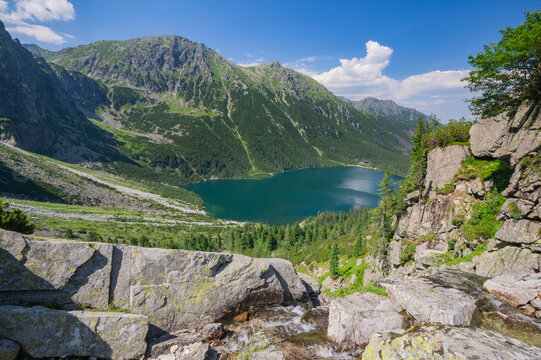 View of Morskie Oko lake's turquoise water amidst the rugged Tatra Mountains, cascading rocks, and vibrant greenery, Zakopane, Wojew&Atilde;&sup3;dztwo ma&Aring;&sbquo;opolskie, Poland.