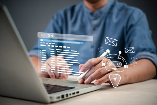 professional using a stylus on a laptop to interact with a virtual AI-powered interface that displays emails and a chatbot, showcasing the role of AI in customer service and digital communication.