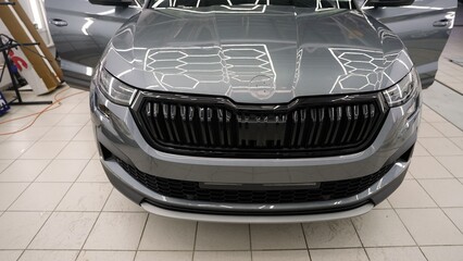 Car detailing process: reflecting lights on polished hood