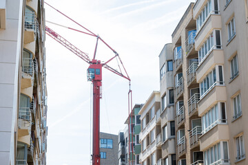 Construction crane near modern house in the city.