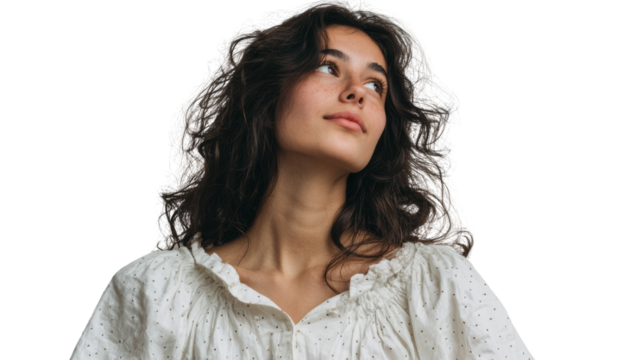 Young woman with curly hair looking upwards, expressing a sense of wonder against a white isolated background.
