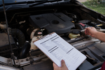 Mechanic checking car engine with inspection checklist, automotive maintenance and repair service...