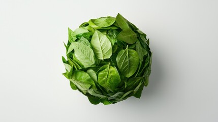 Obraz premium Fresh green spinach leaf top view forming a sphere on a white background for healthy eating and vegan food concepts.