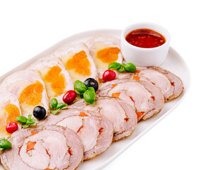 Delicious platter of rolled meats with a variety of garnishes and sauce