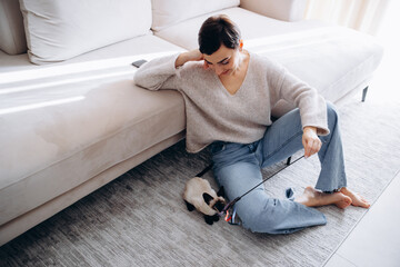 Woman playing with her kitten at home