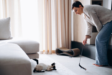 Woman playing with her kitten at home