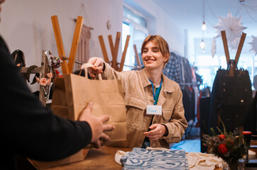 A cheerful cashier helps a customer at the trendy retail stores checkout