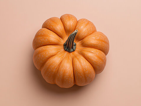 Small orange pumpkin on beige background, top view,