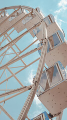 Ferris wheel close up against bright blue sky in sunny summer weather