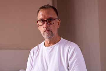 Middle-aged man with glasses in white t-shirt