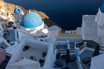 View from viewpoint of Oia village with blue dome of  greek orthodox Christian church and traditional whitewashed greek architecture.  Santorini, Greece