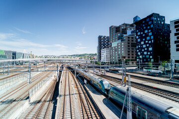 Train at Oslo train station, Norway. Modern Barcode district.	
