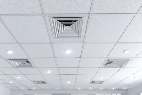 Square ceiling tiles with recessed lighting and ventilation systems.