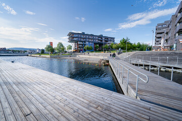 People at the city harbor promenade in Oslo, Norway. A city with modern European architecture.
