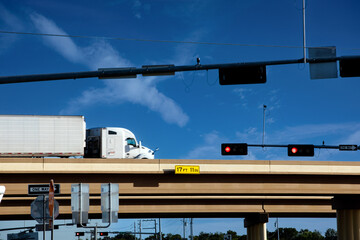 Naklejka premium blurred truck passing by on the elevated highway with traffic lights on the foreground
