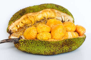 A fresh cempedak (or chempedak) fruit, cut open to reveal the bright yellow, sweet, and aromatic pulp and seeds inside. Captured on a white background.