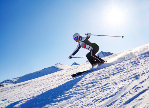 young athletic woman skiing skillfully at ski resort in mountains