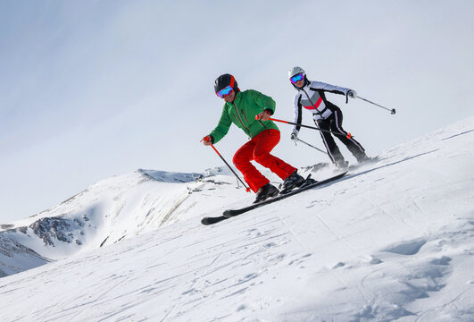 young couple having a great time skiing at a ski resort in the mountains