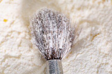 A brush covered in flour grains, side view, macro shot