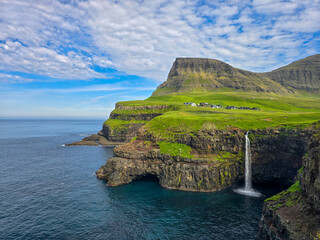 Mulafossur Waterfall cascading into the ocean near Gasadalur village in Faroe Islands