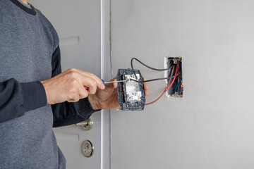 Hands of an electrician working on an electrical installation.
