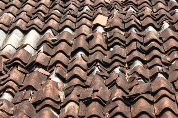 The roof is made of tiles and has a worn appearance