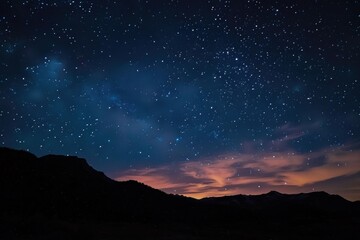 Fototapeta premium Stunning view of a star filled night sky illuminating the silhouette of a mountain range