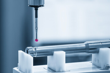 The CMM machine measuring the automotive parts in the blue tone.
