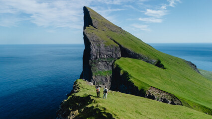 Stunning landscape of the Faroe Islands with hikers exploring majestic cliffs and ocean views