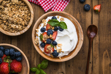 Healthy breakfast bowl with crunchy granola, creamy yogurt and fresh berries. Nutritious and delicious meal, perfect for a balanced diet and clean eating lifestyle