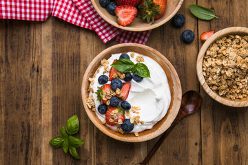 Healthy breakfast bowl with crunchy granola, creamy yogurt and fresh berries. Nutritious and delicious meal, perfect for a balanced diet and clean eating lifestyle