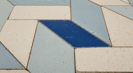 Geometric arrangement of blue, white, and light blue tiles forming a unique pattern on the ground