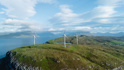 Breathtaking coastal landscape of Faroe Islands with wind turbines against a serene sky