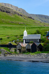Stunning coastal view of the Faroe Islands with traditional architecture and lush green landscapes