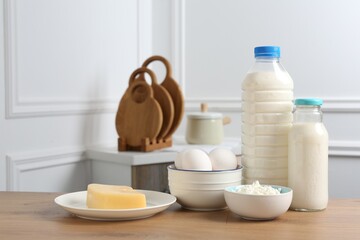 Different dairy products and eggs on wooden table indoors. Space for text