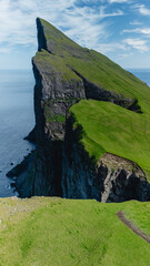Majestic cliff formations overlooking the turquoise waters of the Faroe Islands in bright daylight