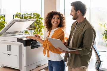 Business partners using printer and laptop in office