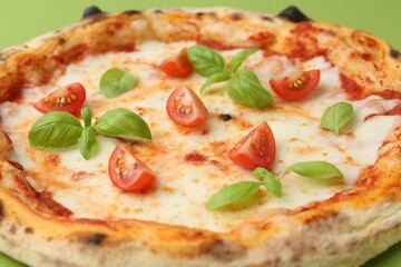 Delicious pizza with tomatoes and basil on table, closeup