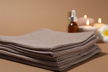 Stack of folded waffle towels on light brown background, closeup